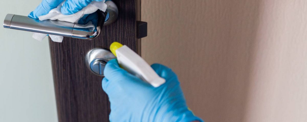 disinfection-services-person-cleaning-door-handle
