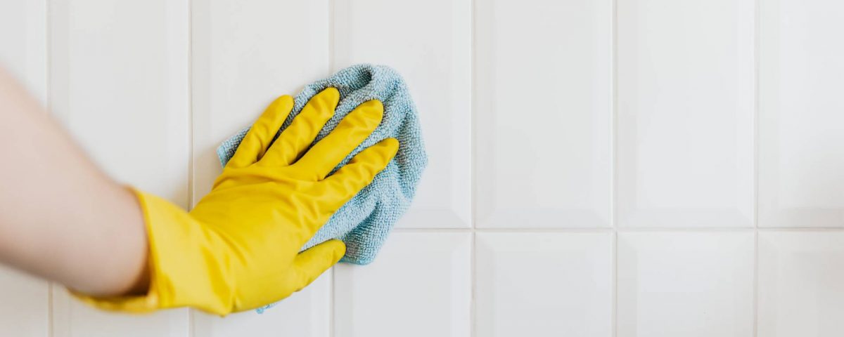 Person cleaning tile with cloth